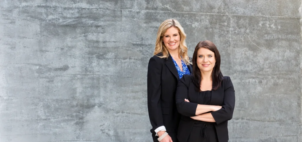 Confident corporate duo against concrete 1024x484